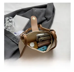 Interior view of small square bag showing storage for phone, wallet and cosmetics