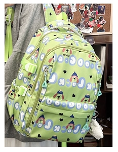 Vue détaillée du sac à dos vert clair avec motif de chien et breloque en peluche