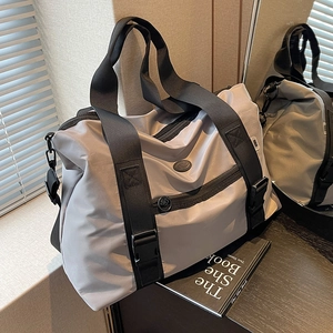 Sac fourre-tout en nylon gris clair avec poignées noires et bandoulière pour le voyage