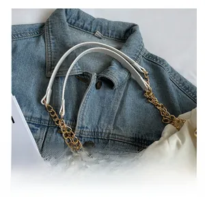 Close-up of quilted white nylon tote showing chain strap and fine material texture