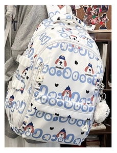 Détail d'un sac à dos blanc avec imprimé chien bleu et porte-clés pompon blanc