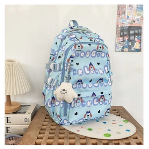 Détail du sac à dos en toile bleu clair avec motifs chiens et pendentif étoile en peluche