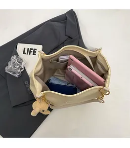 Top view of spacious beige tote bag interior showing laptop and daily essentials