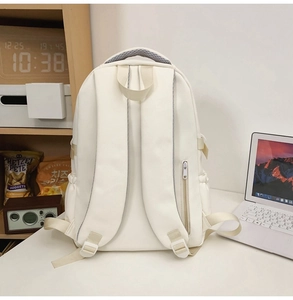 Back view of minimalist cream backpack featuring anti-theft zipper and wide padded straps