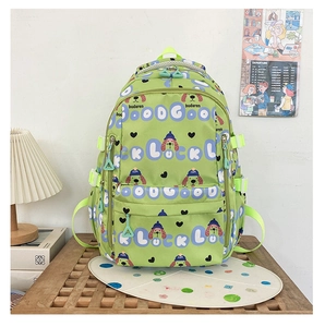 Détail d'un sac à dos vert pour enfants avec motif de chien et grande poche avant zippée