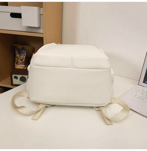 Detailed back view of minimalist white canvas backpack with adjustable straps and clean texture