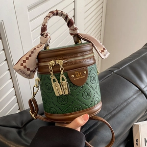 Dunkelgrüne Beuteltasche mit Logo-Prägung und Seidentuchwicklung am Handgriff