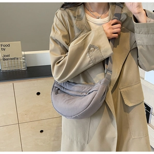 Detail of grey nylon crescent crossbody bag with front zipper and adjustable wide strap