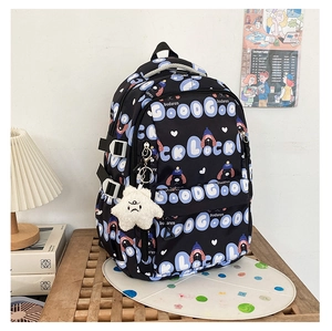 Détail du sac à dos en nylon noir avec texte Good Luck et pendentif étoile en peluche