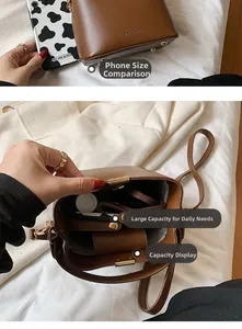 Close-up of brown leather bucket bag showing interior space and size vs a smartphone