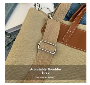 Close-up of the adjustable strap buckle on a beige canvas and brown leather tote bag