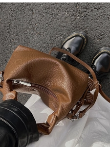 Vue macro d'un sac en cuir texturé marron foncé avec détail de bandoulière nouée