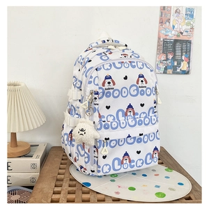 Gros plan du sac à dos en toile blanche avec motifs de chiens bleus et porte-clés