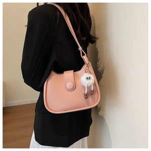 Pink leather shoulder bag detail with cute white plush monster charm accessory