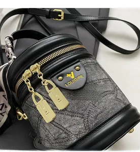 Détail du sac seau en jacquard gris avec ferrures dorées, finitions cuir et foulard