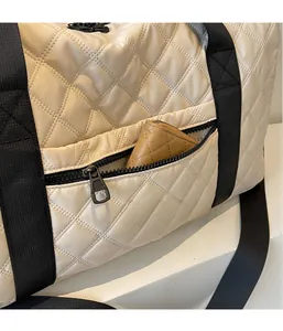 Detailansicht der gesteppten Reisetasche mit Reißverschlussfach und schwarzen Riemen