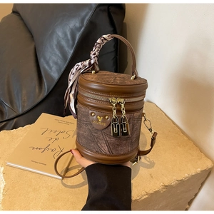 Vue détaillée du sac seau marron vintage avec foulard décoratif et fermetures éclair dorées
