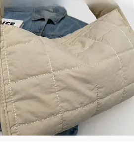 Detail of the soft quilted fabric and high-quality stitching on a beige canvas tote bag