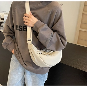 Detail of beige nylon crossbody bag with adjustable wide strap and pleated texture