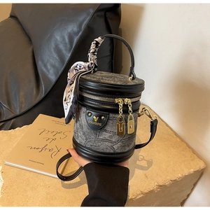 Détail du sac seau en denim gris avec garniture en cuir et poignée en foulard de soie