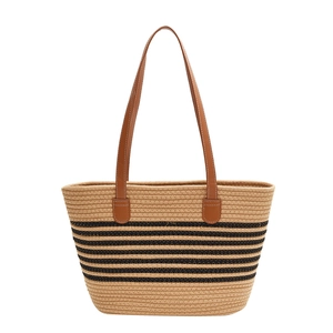 Large woven straw tote bag with black stripes and brown leather straps for beach or daily use