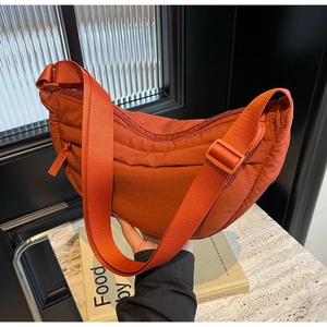 Close-up of caramel quilted nylon tote bag with wave stitching and adjustable strap