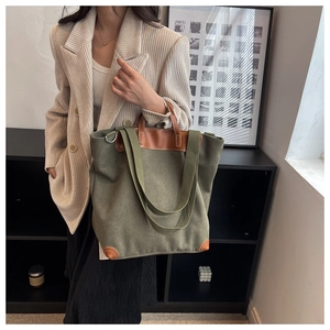 Detalle de bolso tote de lona verde militar con ribete de cuero y correa ancha al hombro