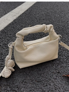 Détail du sac à bandoulière plissé beige en cuir grainé avec poignée nouée