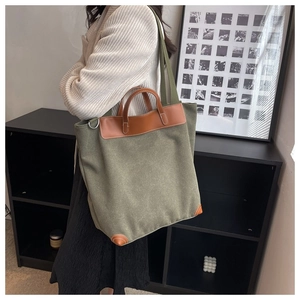 Detalle del bolso tote de lona con adornos de cuero y correa de hombro ajustable