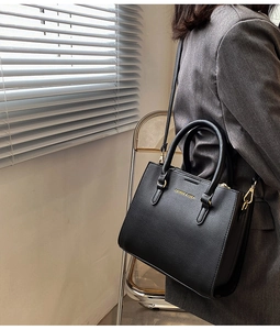 Detail of black pebbled leather tote bag with gold hardware and removable shoulder strap