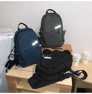 Detailed view of waterproof nylon backpacks with reflective strips and small monkey charms