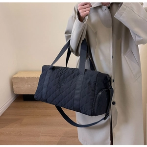 Detail der schwarzen gesteppten Reisetasche mit verstärkten Gurten und Reißverschluss