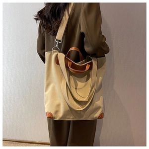 Vista trasera de modelo con bolso de lona grande y detalles de cuero marrón