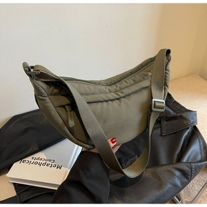 Detail of olive green nylon crescent bag with adjustable wide strap and smooth zipper
