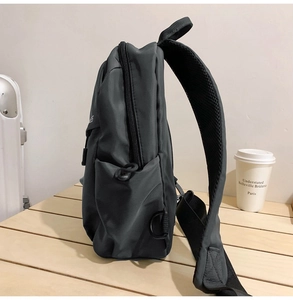 Side view of dark gray backpack featuring adjustable breathable mesh shoulder straps