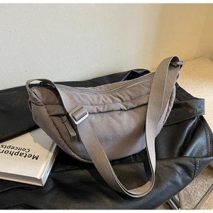 Detailed close-up of dark grey nylon crescent bag with adjustable strap and zip closure