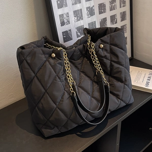 Black quilted nylon tote bag with golden metal chain straps and diamond lattice pattern