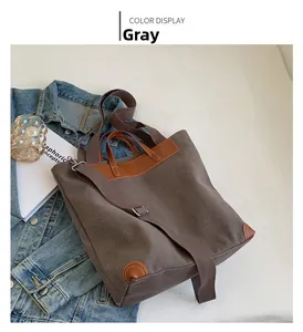 Detail view of grey canvas tote bag with brown leather trim and adjustable shoulder strap
