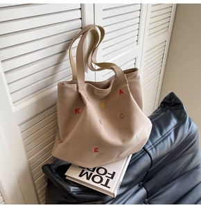 Detailed view of canvas tote bag with colorful embroidery and KFBAG leather brand tag
