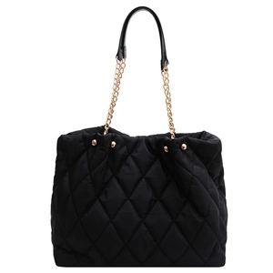 Quilted black nylon tote bag with golden chain straps and diamond lattice stitching