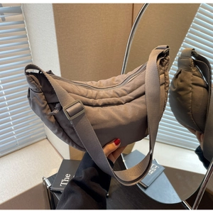 Mirror reflection showing the texture and back detail of a grey nylon crescent tote bag