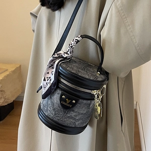 Sac seau en jacquard gris avec bordure en cuir noir et foulard décoratif sur la poignée