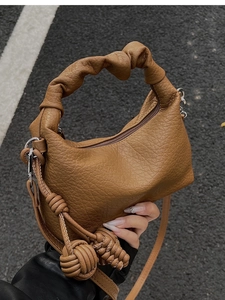 Vue de dessus d'un sac à main caramel texture litchi avec anse plissée et ornement
