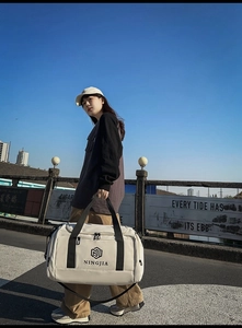 Detail shot of the large capacity white nylon travel bag with branded logo and black strap