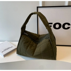 Deep green quilted canvas tote bag with padded texture and metallic top zipper closure