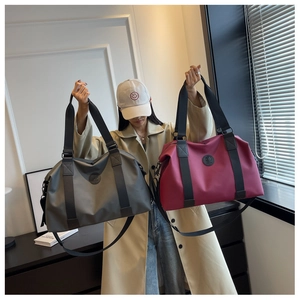 Model holding waterproof oxford cloth travel bags in dark grey and burgundy colors