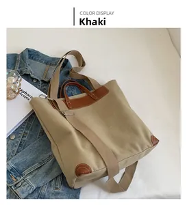 Detail view of khaki canvas tote bag with brown leather corners and wide shoulder strap