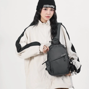 Dark grey large nylon crossbody chest bag with adjustable shoulder strap and charm