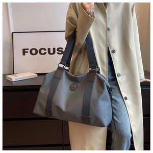 Fashionable model carrying a grey large capacity waterproof oxford travel bag on shoulder