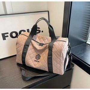 Nahaufnahme der altrosa gesteppten Reisetasche mit Markenlogo und Reißverschluss